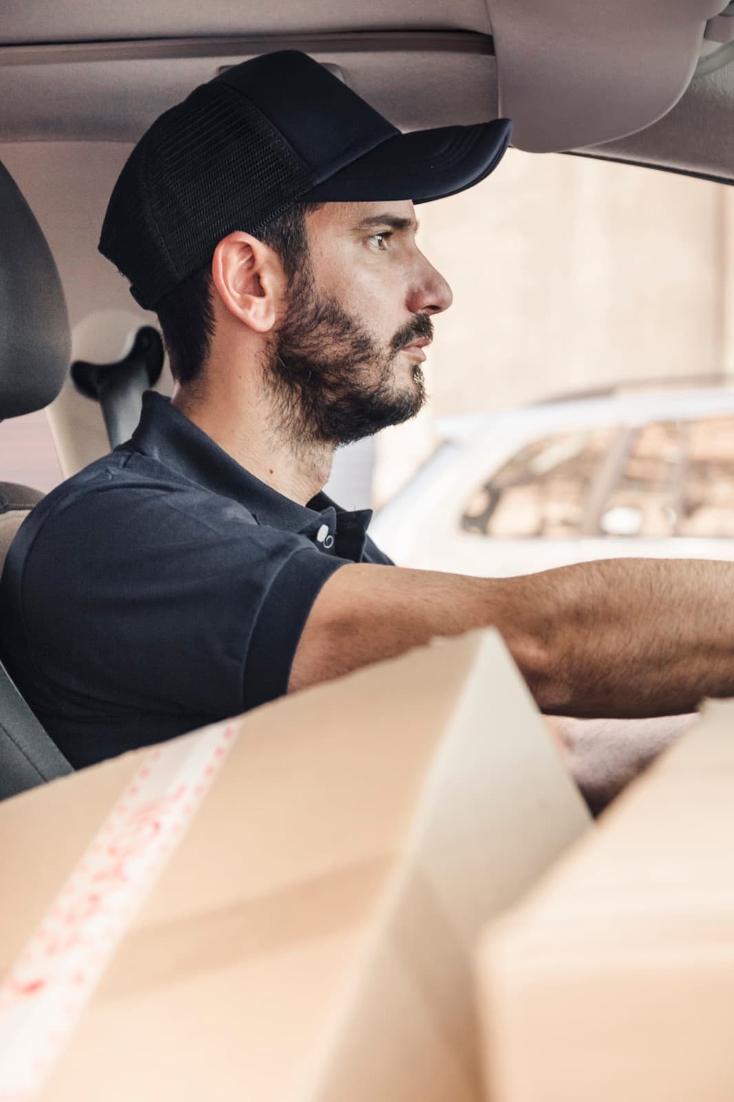 Repartidor de Fleeto al volante, con paquetes listos para entregar